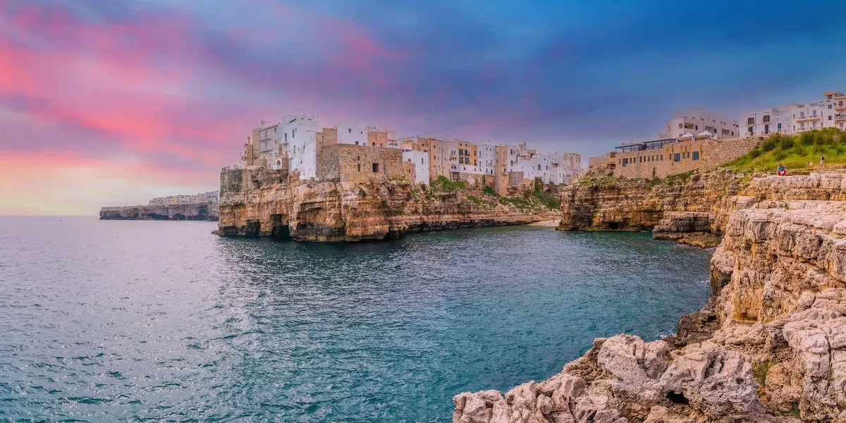 Plage Lama Monachile encadrée par les falaises calcaires de Polignano a Mare, mer Adriatique, Pouilles