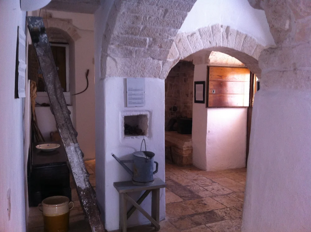 Intérieur voûté d'un trullo à Alberobello, architecture conique en pierre calcaire sèche avec mobilier d'époque, Pouilles, Italie