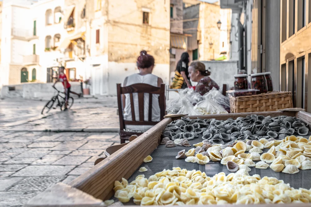 Nonna des ruelles de Bari Vecchia roulant des orecchiette à la main, tradition culinaire des Pouilles