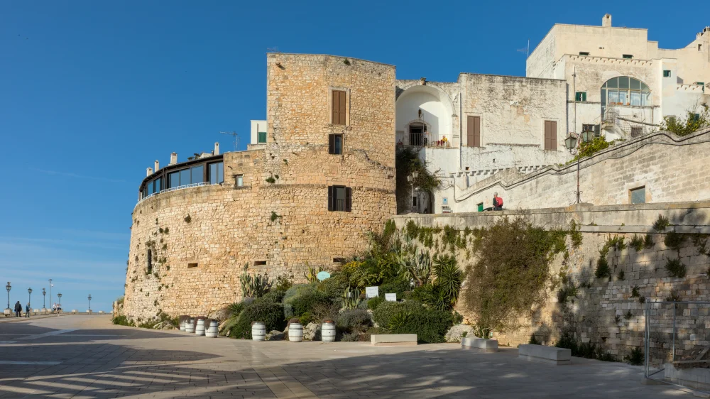 Remparts aragonais d'Ostuni avec vue plongeante sur la canopée d'oliviers et l'Adriatique au loin, Pouilles