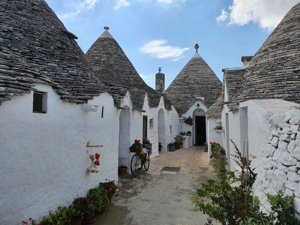 Ruelle pavée bordée de trulli blancs dans le quartier Aia Piccola, Alberobello, Pouilles, Italie
