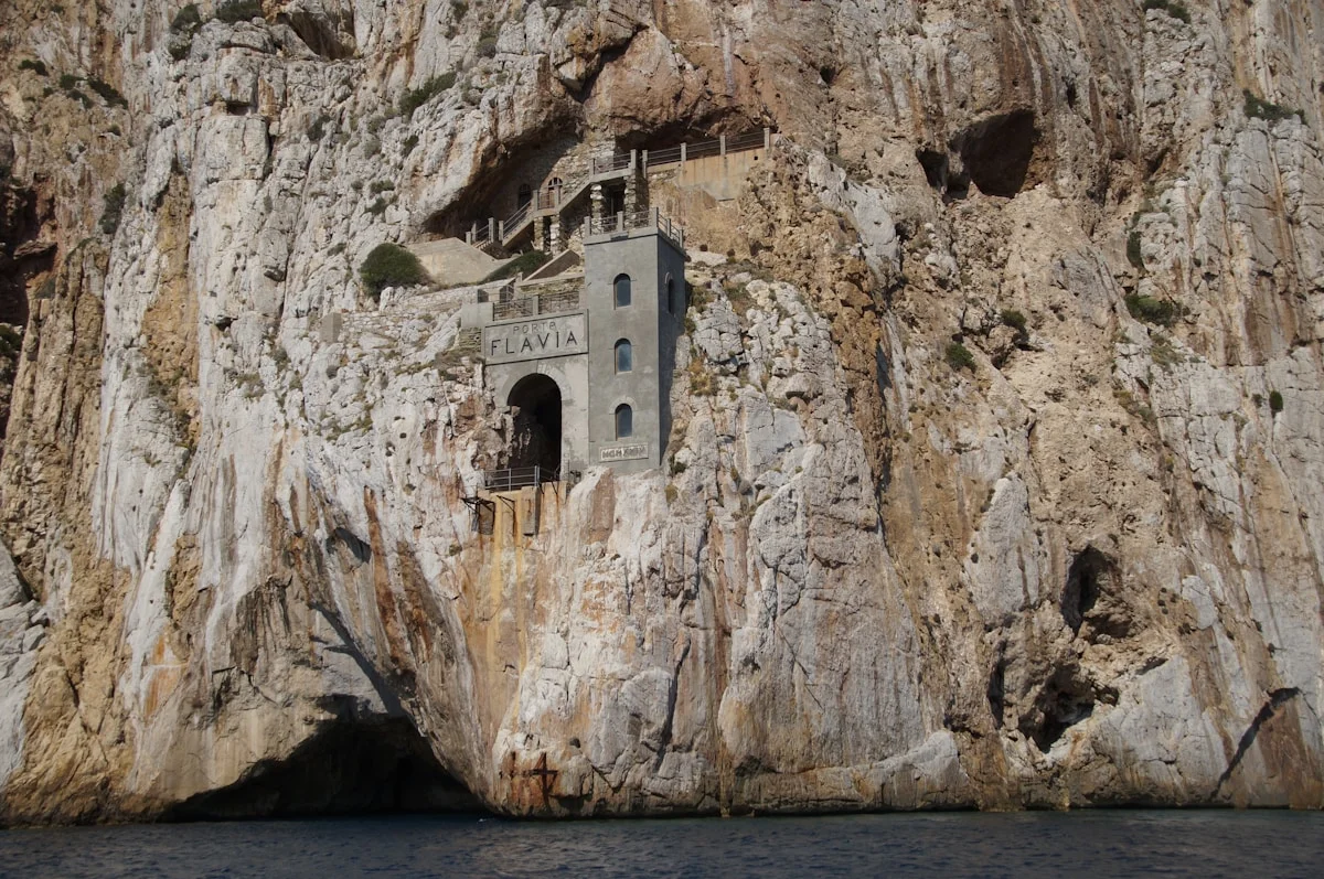 La falaise abrupte de Porto Flavia et le rocher de Pan di Zucchero dans l'eau, Sardaigne