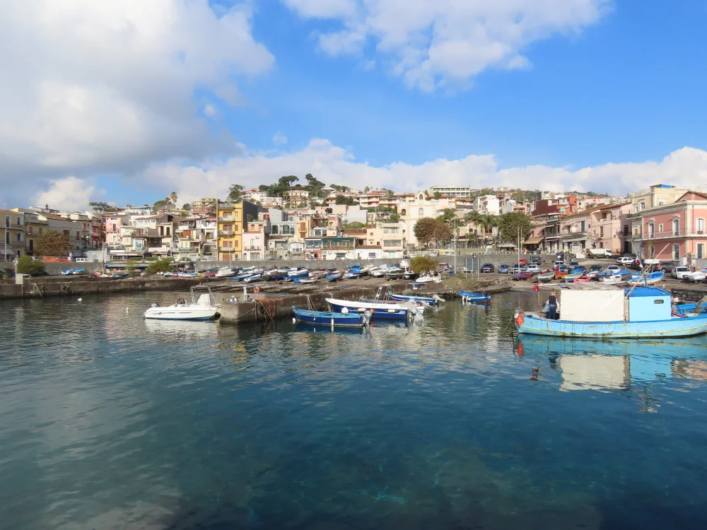 Port d'Aci Trezza et les faraglioni basaltiques dans la mer Ionienne, côte est de la Sicile, juin
