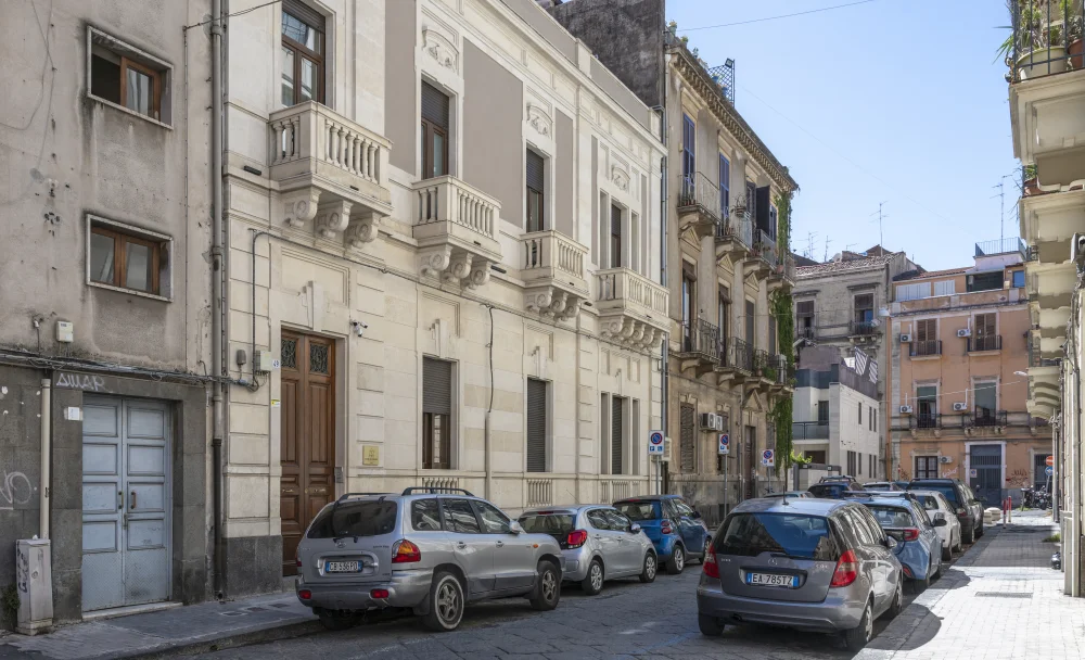 Rue avec voitures garées en lignes de stationnement dans une ville de Sicile