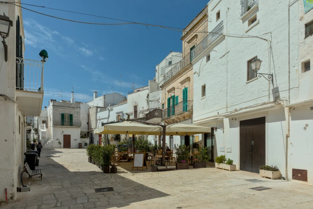 Place Pellegrino Rossi de Cisternino avec ses façades blanches immaculées sous le soleil, Vallée d'Itria, Pouilles