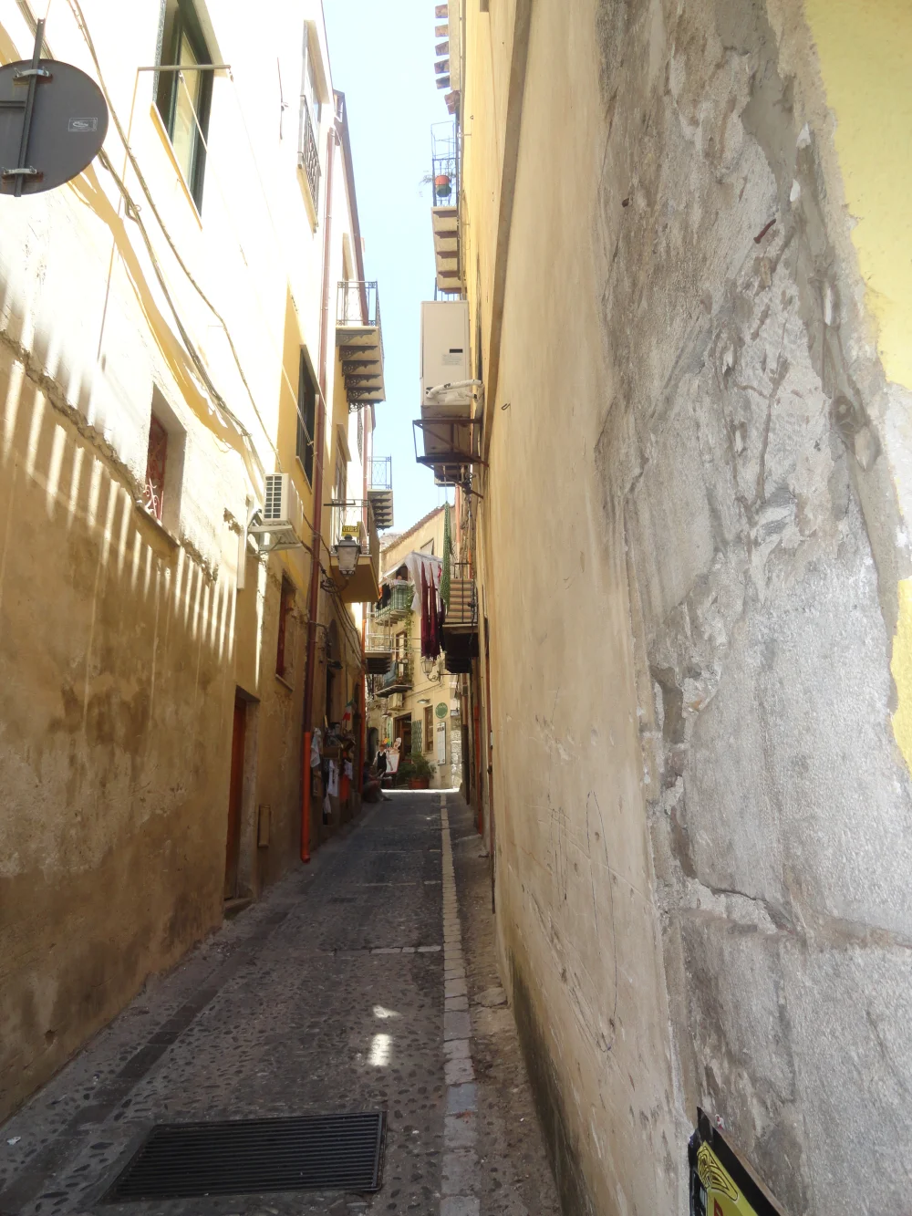 Ruelle pavée et étroite du centre historique de Sicile, difficile à traverser en voiture, bâtisses ocre de chaque côté