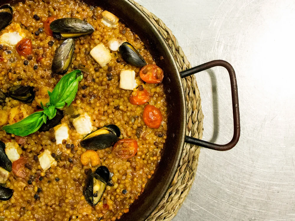 Fregola sarda aux palourdes et fruits de mer dans un bouillon iodé, plat de l'été sarde, août
