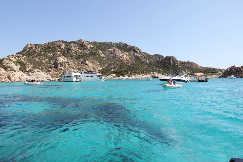 Bateau ancré dans la crique de Cala Corsara sur l'île de Spargi, eaux transparentes, archipel de La Maddalena, Sardaigne