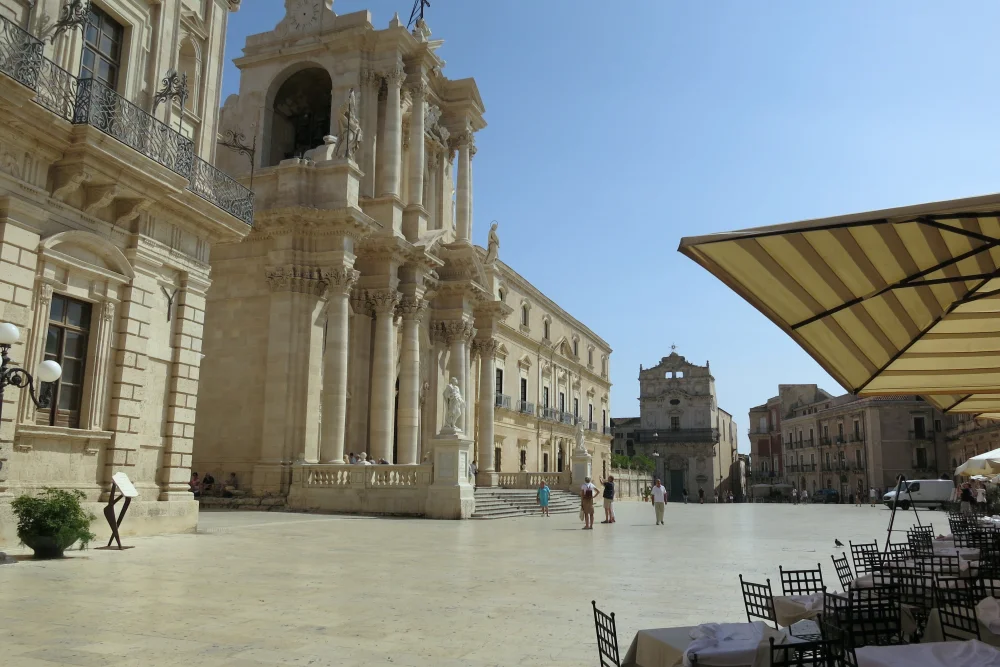 Piazza del Duomo d'Ortigia à Syracuse, façades baroques en calcaire blanc sous un ciel bleu éclatant, Sicile