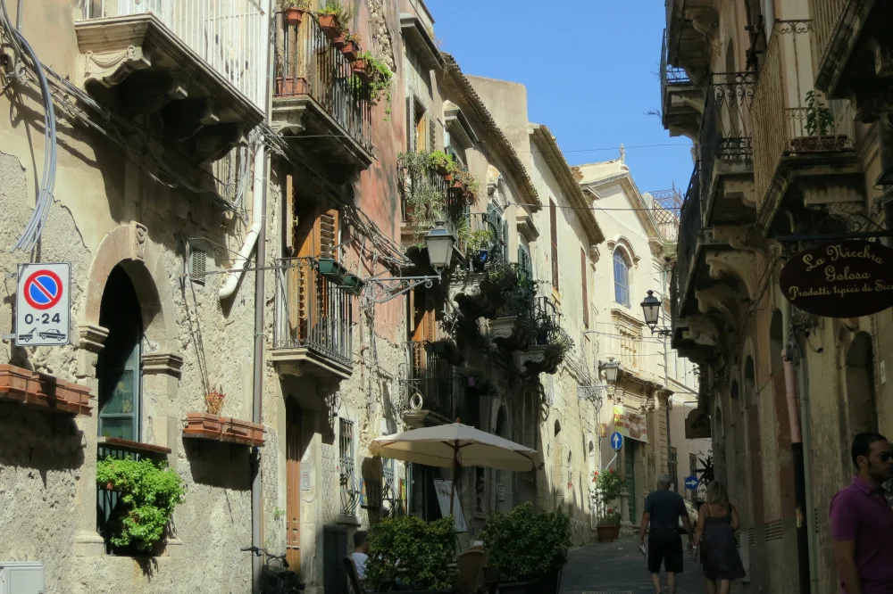 Ruelle baroque d'Ortygie avec balcons en fer forgé et façades calcaires dorées au soleil, Syracuse, Sicile