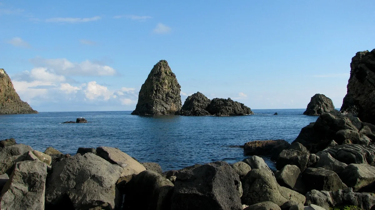 Les Faraglioni d'Aci Trezza, pitons de basalte prismatique émergeant des eaux transparentes de la mer Ionienne, Sicile