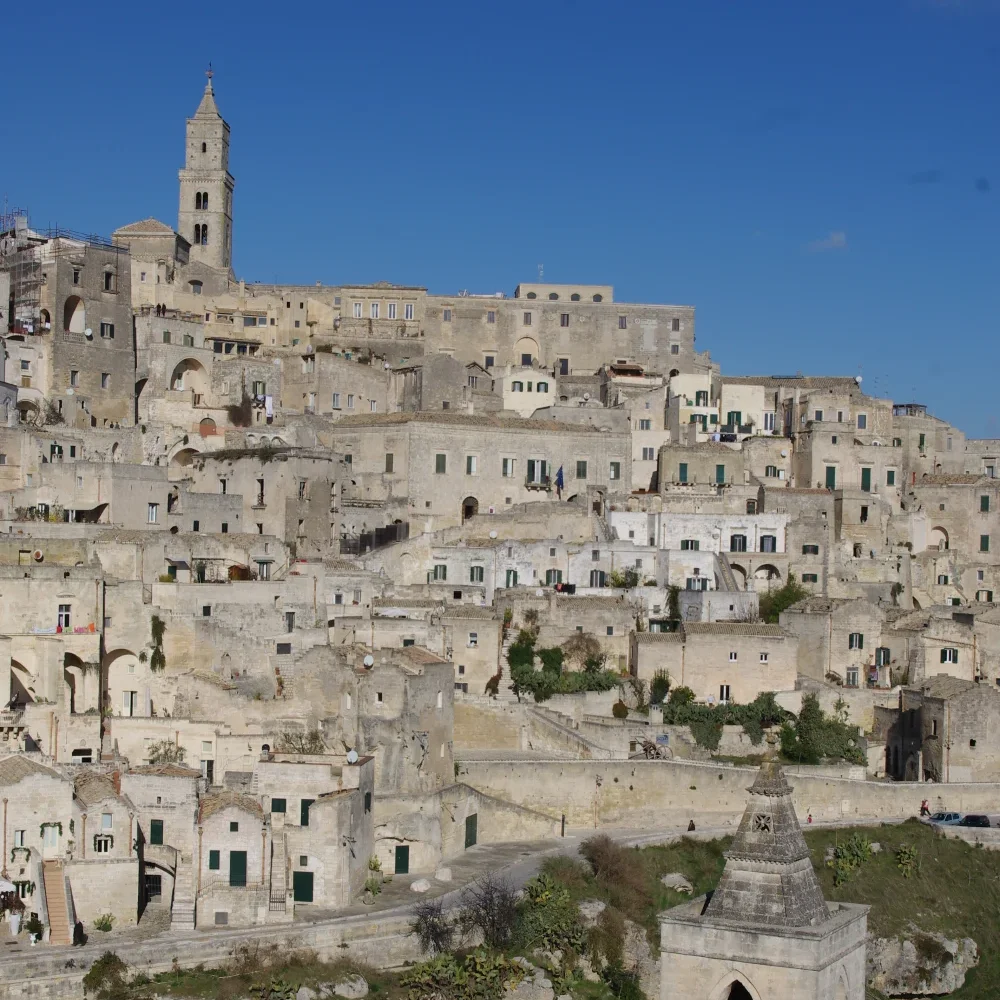 Panorama des Sassi de Matera à l'heure dorée, grottes et maisons troglodytes éclairées doucement au coucher du soleil, Basilicate