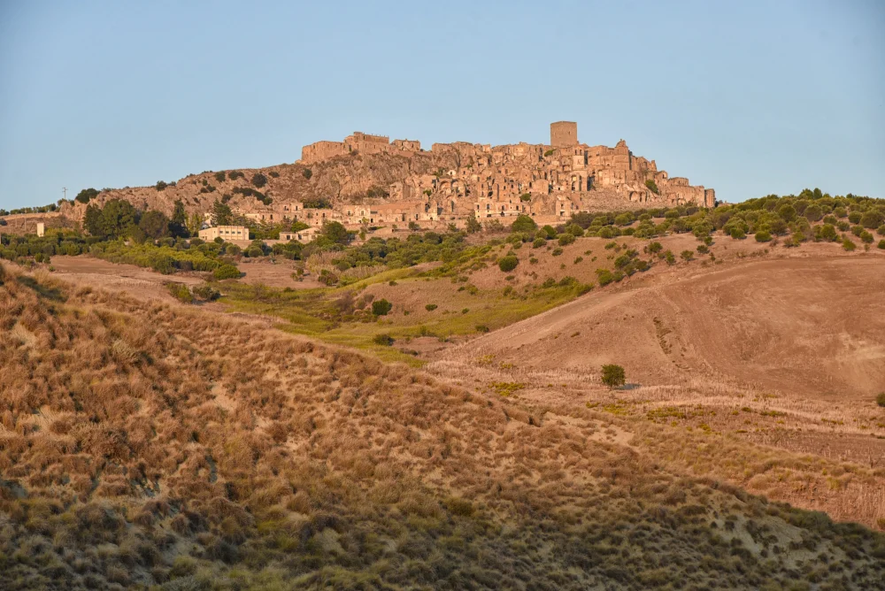 Visiter Craco - Paysage de Craco perché sur sa colline d'argile, entouré des calanchi de Basilicate, Italie du Sud