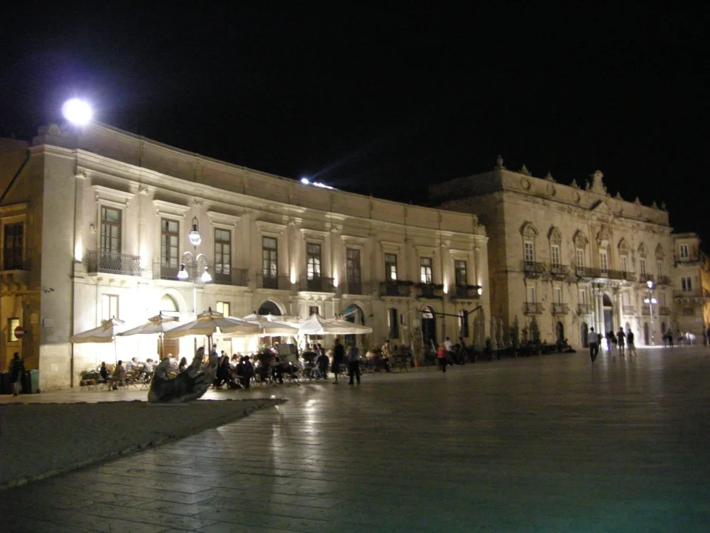 Piazza del Duomo d'Ortigia de nuit, reflets dorés des lampadaires sur les dalles de calcaire, Syracuse