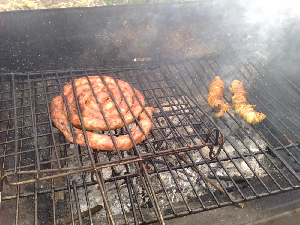 Stigghiola grillée sur des braises dans la fumée des rues de Palerme pendant le Festino