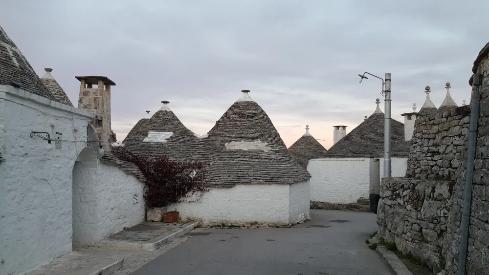 Ruelle pavée d'Alberobello bordée de trulli aux toits de pierre grise, vallée d'Itria, Pouilles