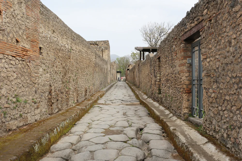 Rue pavée de basalte avec passages piétons surélevés et ornières de chars, étape obligée pour visiter pompei