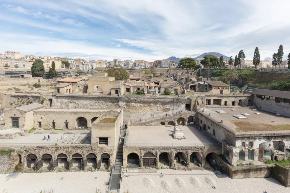 Ruines d'Herculanum avec la ville moderne d'Ercolano en surplomb et le cône du Vésuve à l'arrière-plan