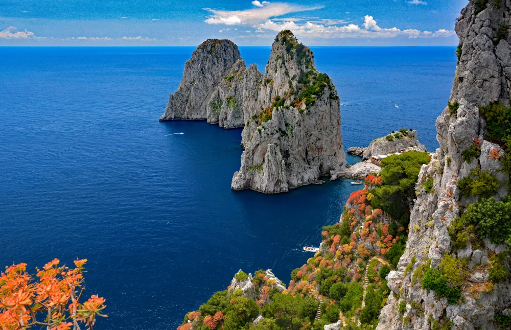 Rochers des Faraglioni de Capri vus depuis un sentier côtier au-dessus de l'eau bleue
