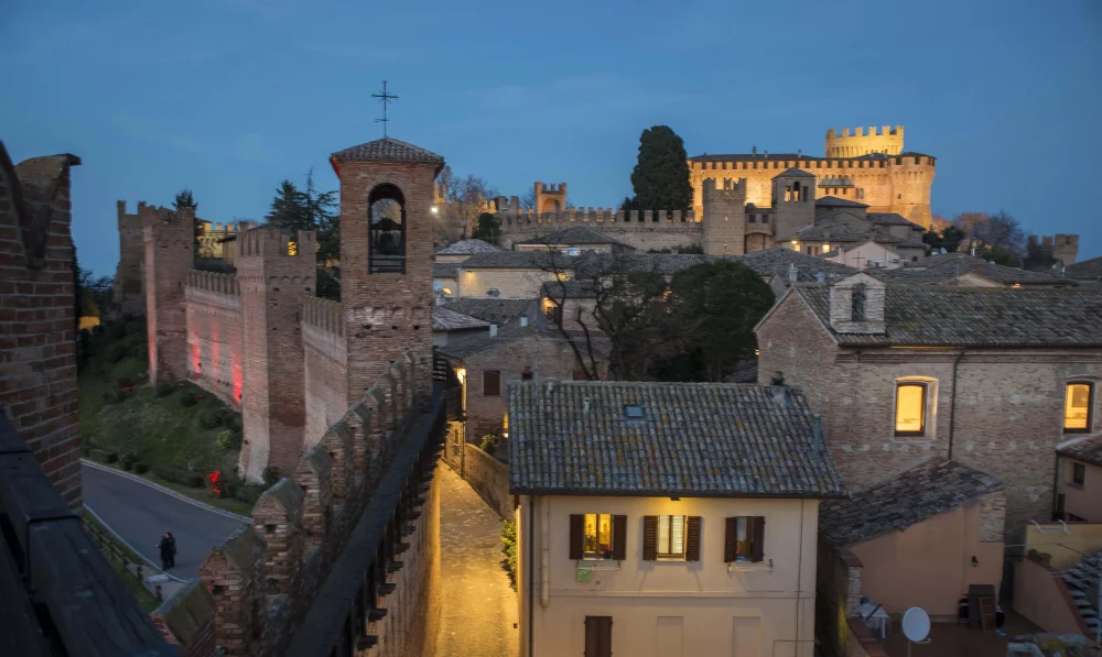 Château de Gradara illuminé au crépuscule, silhouette du donjon sur le ciel des Marches