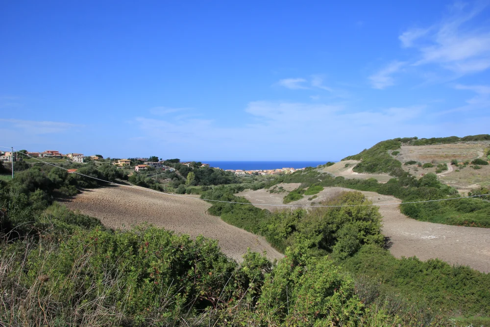 Plage de Lu Bagnu près de Castelsardo, falaises claires et maquis en arrière-plan, Sardaigne