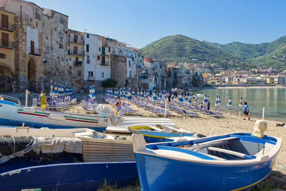 Vue de Cefalù depuis la mer avec une barque de pêcheur au premier plan, Sicile