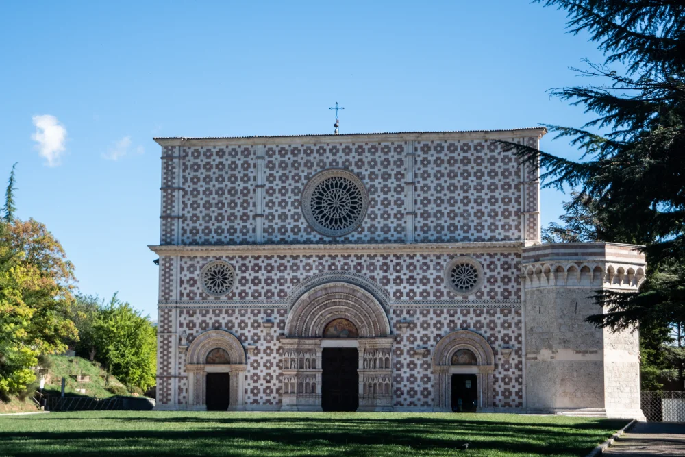 Façade en pierre blanche et rose de la Basilique de Collemaggio à L'Aquila