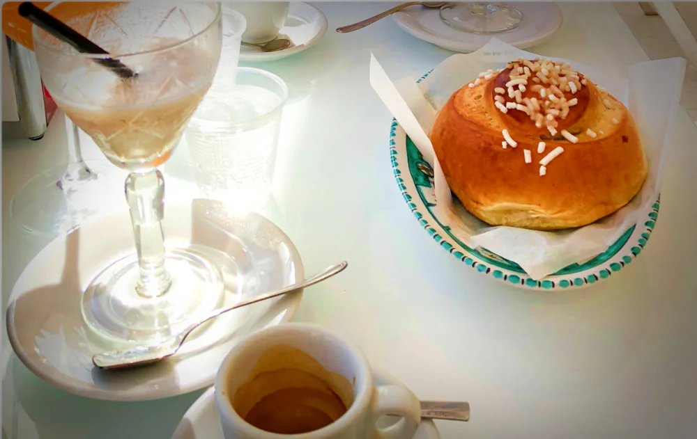 Granita à l'amande servie avec une brioche col tuppo et un café, Catane