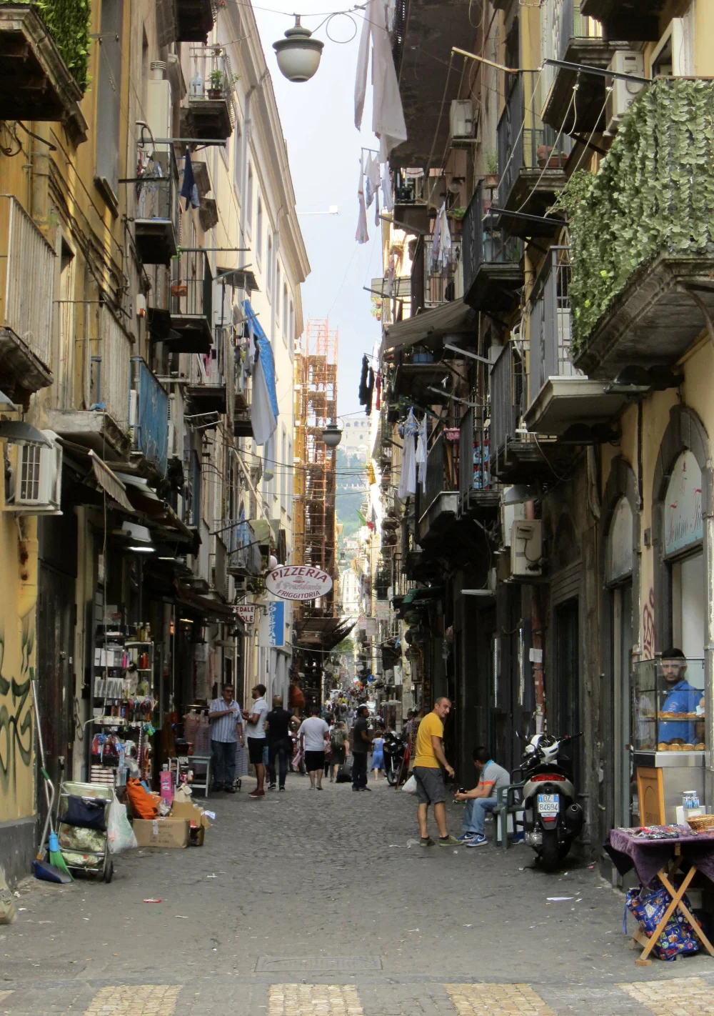 Ruelle de Spaccanapoli à Naples, linge suspendu aux balcons, scooters garés sur le trottoir, début de l'itinéraire d'une Semaine à Naples