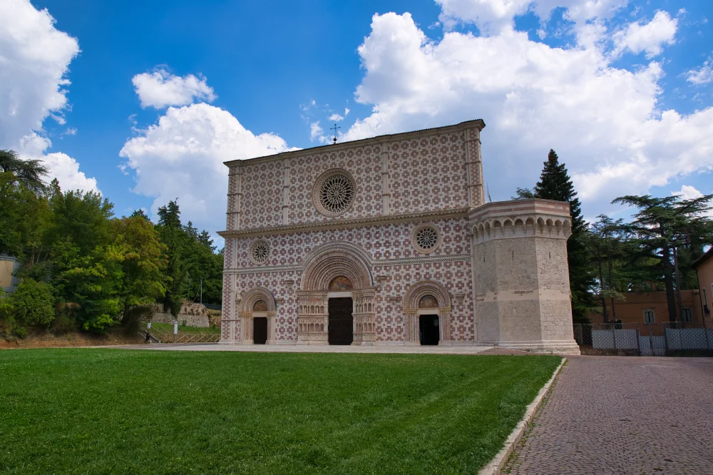 Façade géométrique blanche et rose de la basilique de Collemaggio à L'Aquila
