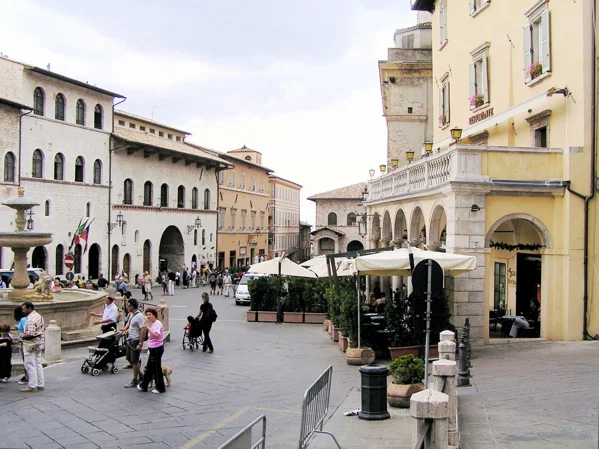 Piazza du centre historique d'Assise bordée de palais en pierre rose du Subasio