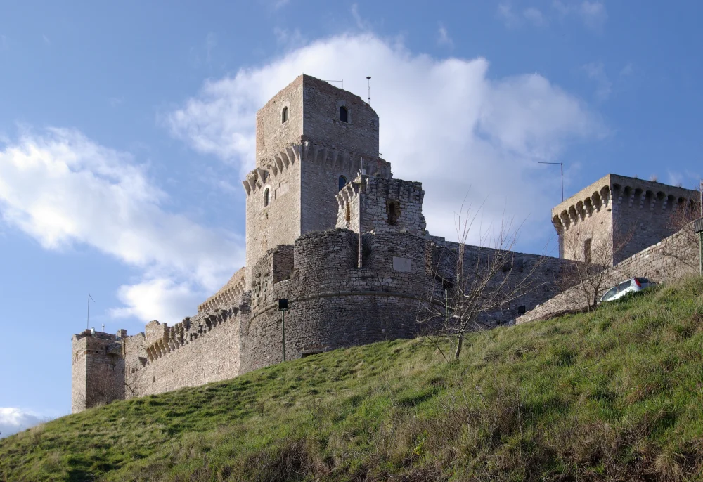 Tours et remparts de la Rocca Maggiore surplombant Assise au coucher du soleil