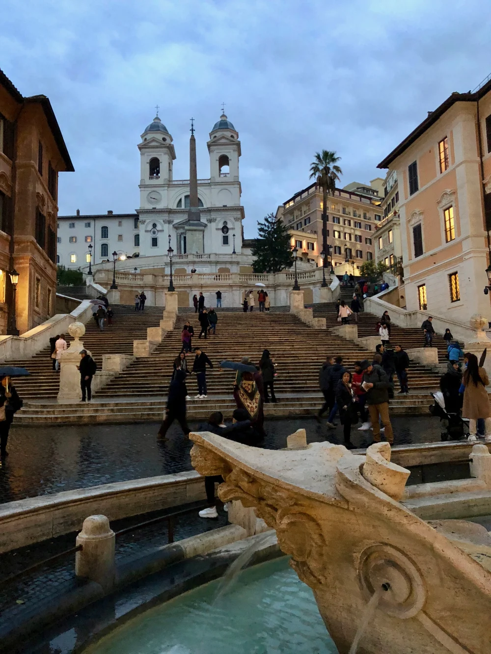 Escalier de la Piazza di Spagna sous la pluie à Rome, promeneurs avec parapluies en novembre